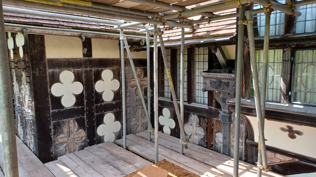 Taken from the scaffolding during Phase 3 of the Big MEND project at Wightwick Manor, some lime rendering has been removed from the decorative quatrefoils revealing the wooden beams underneath. The detail of the decorative lead downpipe is also shown to the side of the bay window.